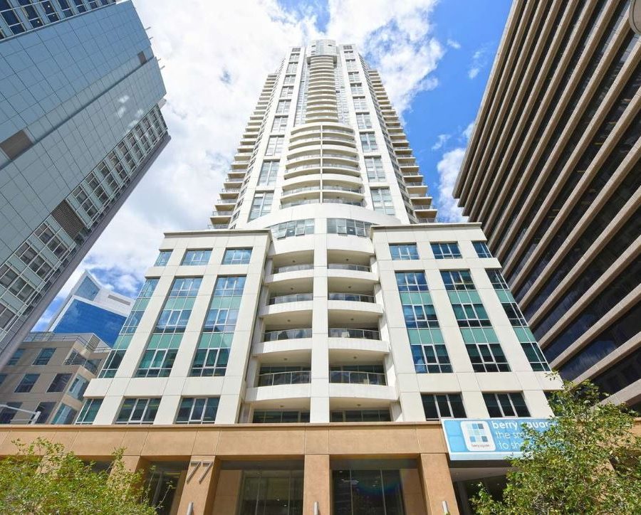 External facade of The Alexander Apartments among high rise buildings.